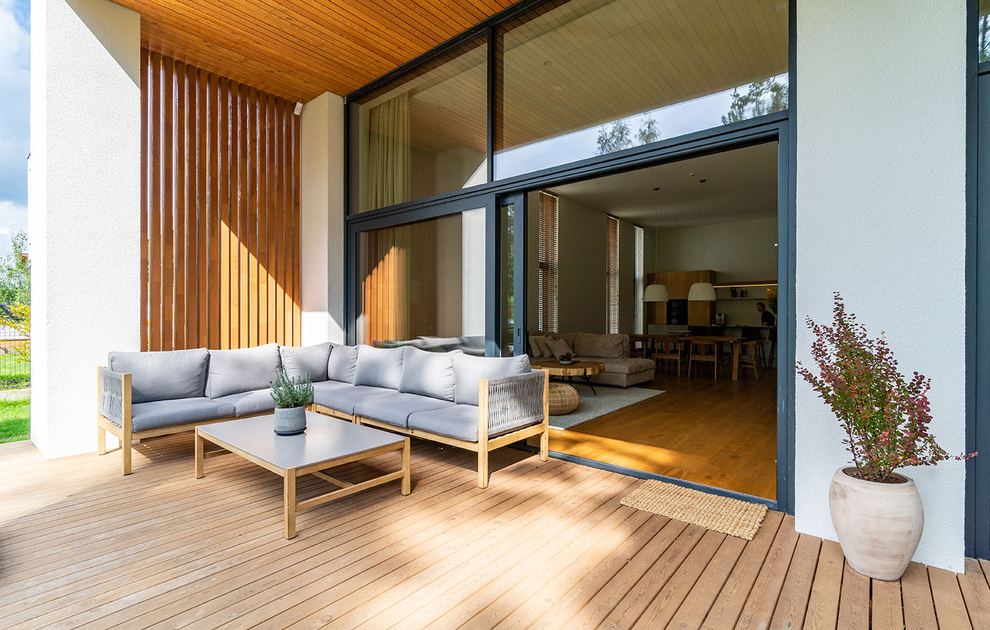 Eine elegante Terrasse können auch Sie sich bauen Blick auf Terrasse mit moderner Holzfassade und eleganten Terrassenmöbeln