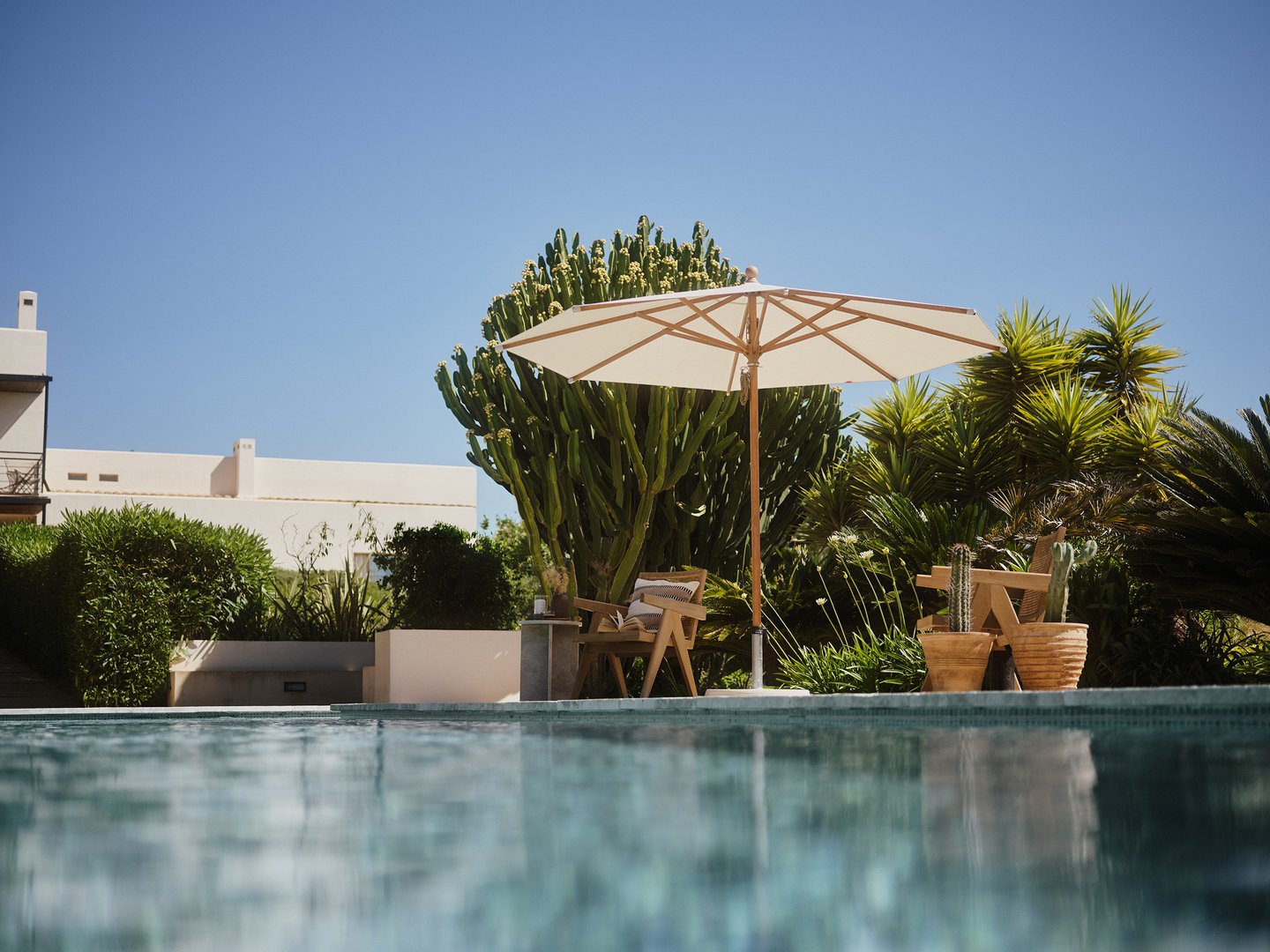 Moderner Garten mit Pool und Holzoptik Sonnenschirm von Glatz für stilvollen Schatten auf der Terrasse